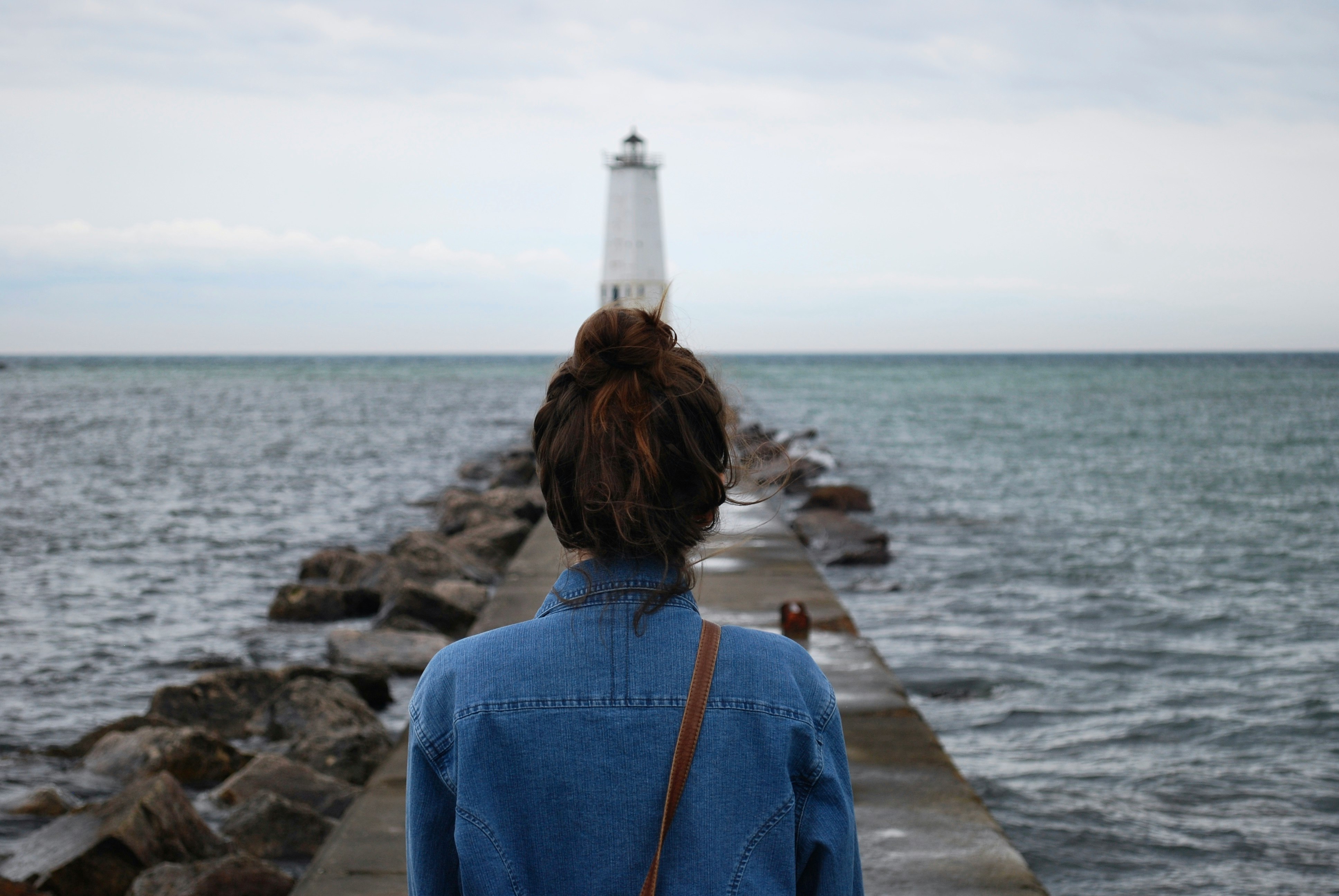 woman standing infront of lighthouse near beach